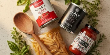 Four pantry staples ready for quick meal preparation: canned tomatoes, dry pasta, black beans, and marinara sauce.